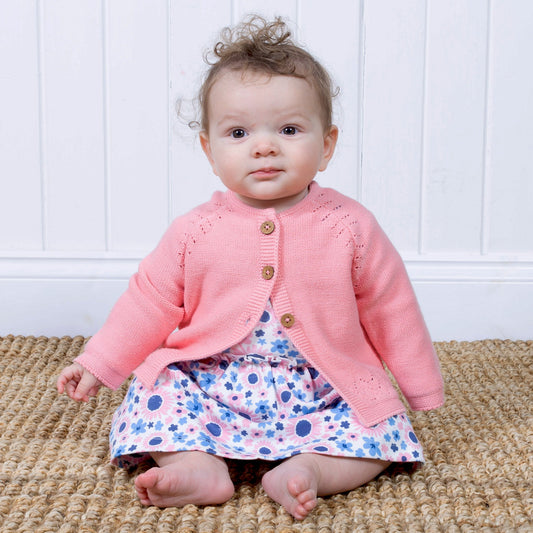 Baby wearing pink cardigan with dress