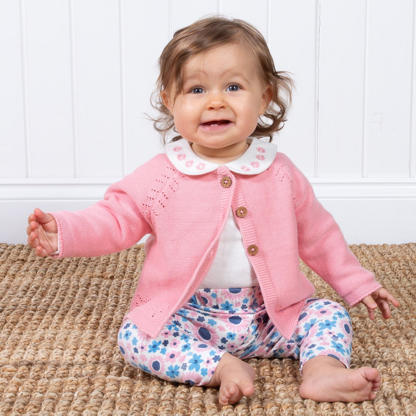 Baby wearing pink cardigan with top and trousers