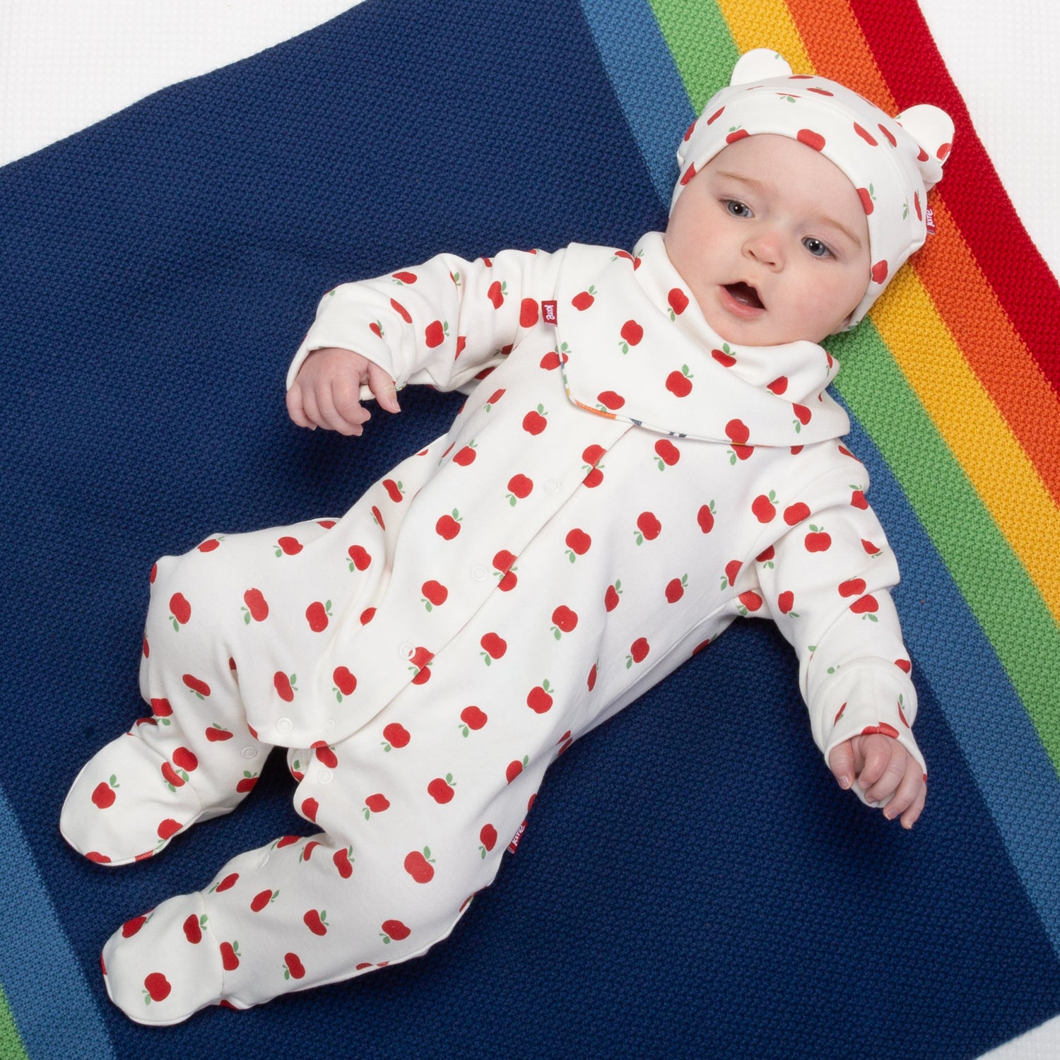 Baby wearing apple dot sleepsuit
