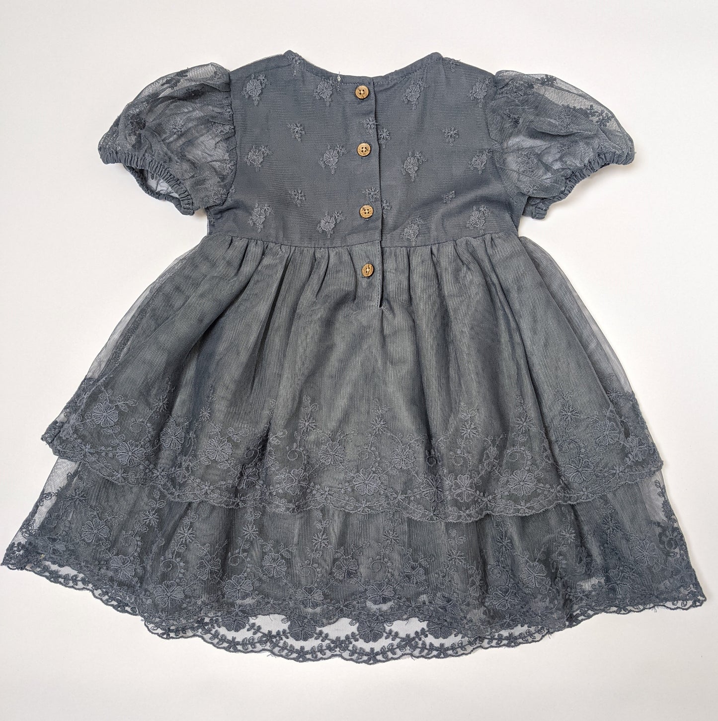 Back of blue lace dress showing wood imitation buttons