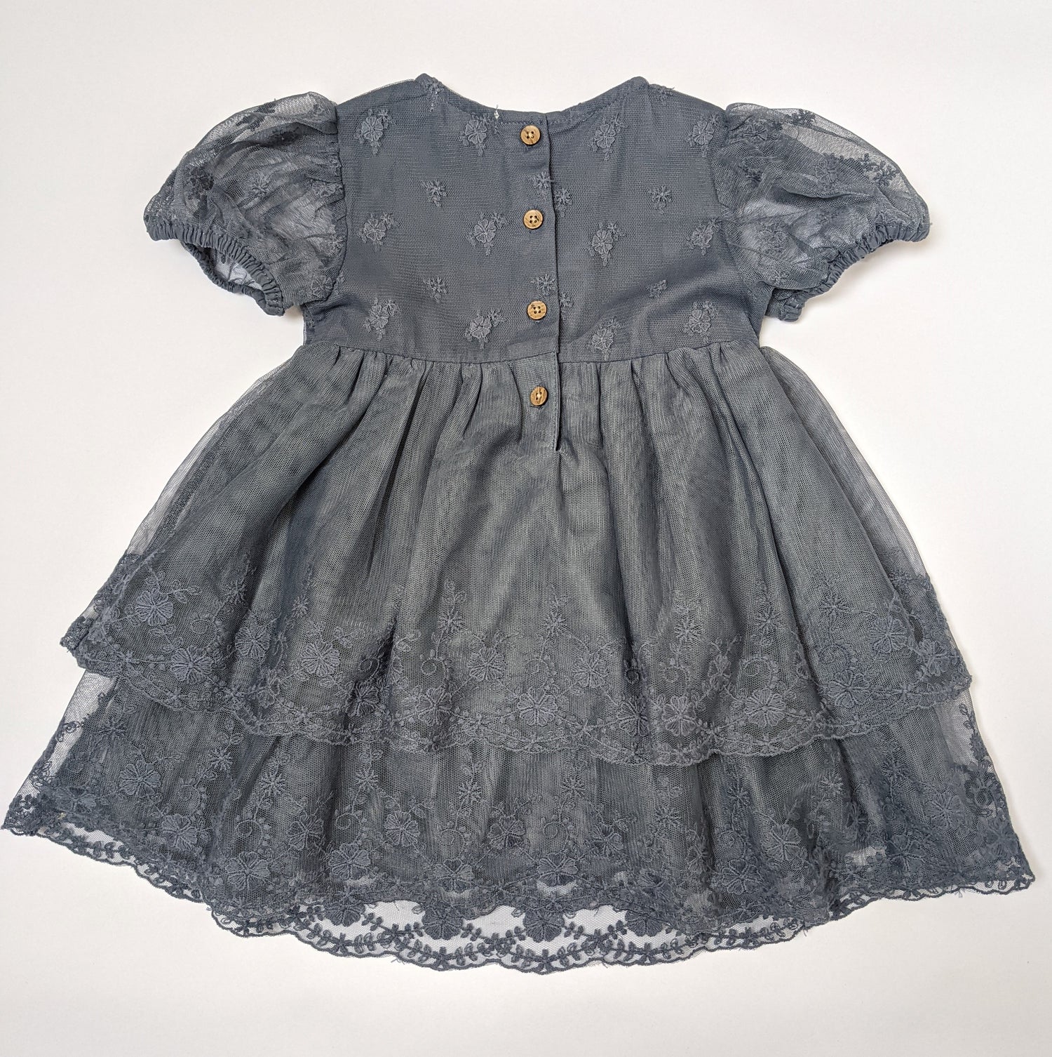 Back of blue lace dress showing wood imitation buttons