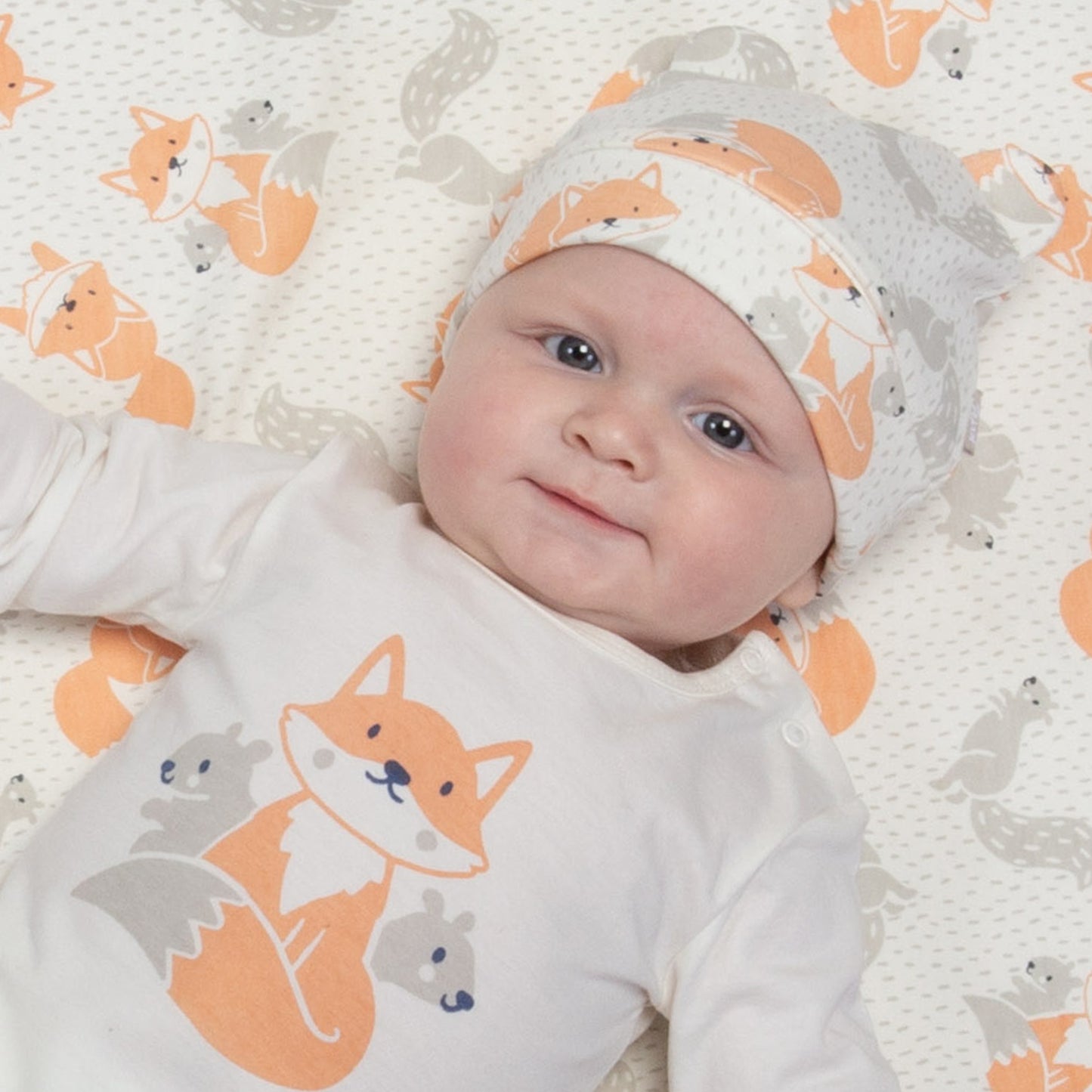 Baby wearing fox and squirrel hat