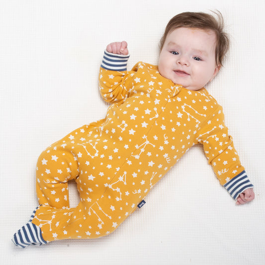Baby wearing yellow sleepsuit with star print