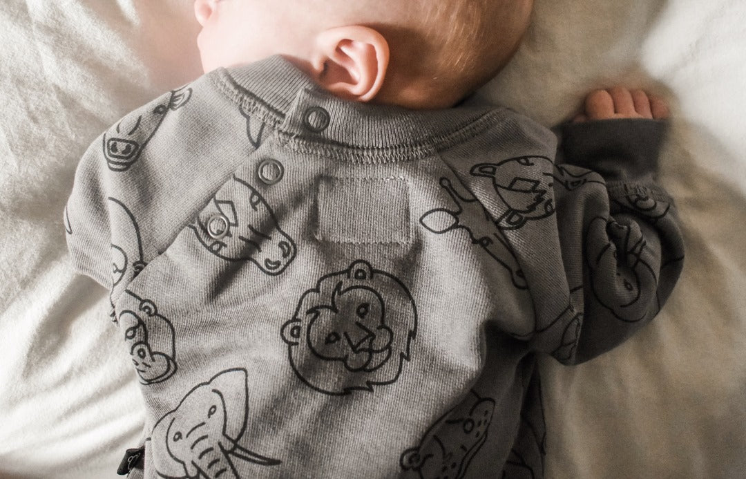 Baby wearing grey jumper with animal print