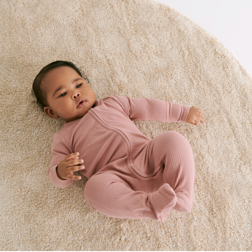 Baby wearing rose zip up sleepsuit